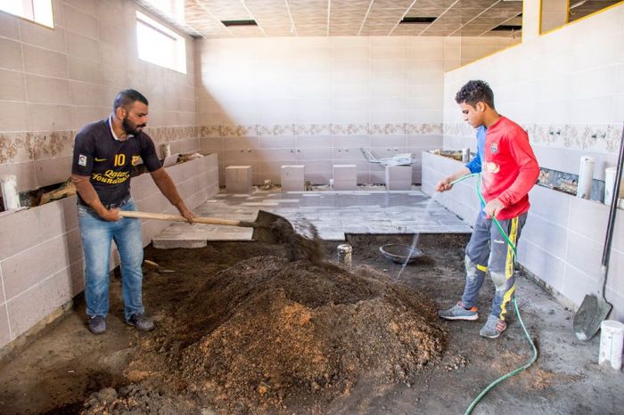 يتواصل العمل الدؤوب في تطبيق أرضية بناية الصحيات الخارجية .